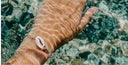 weibliche Hand mit Armband unter Wasser im Sommer 