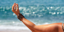 Kugelarmbänder auf Arm einer Frau am Strand